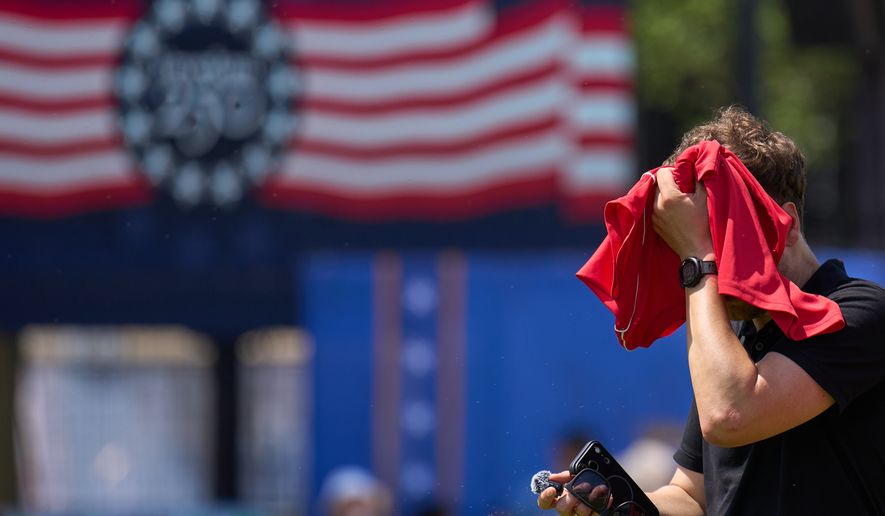 A man wipes sweat off of his head while attending the Great American State Fair, on the National Mall, Wednesday, July 1, 2026, in Washington. (AP Photo/Jacquelyn Martin)