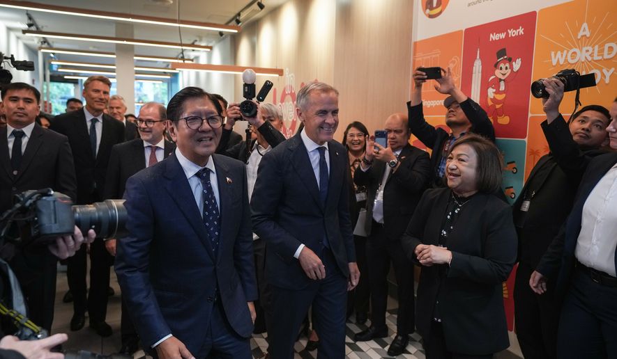 Canada's Prime Minister Mark Carney, center, and Philippines President Ferdinand Marcos Jr., right, arrive for a visit to a Jollibee fast food restaurant, in Vancouver, Thursday, July 2, 2026. (Darryl Dyck/The Canadian Press via AP)
