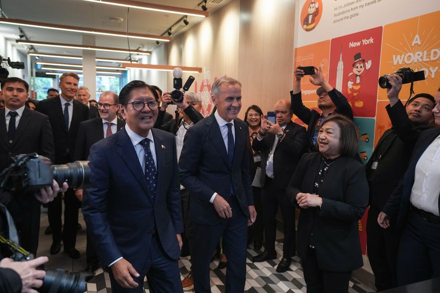 Canada's Prime Minister Mark Carney, center, and Philippines President Ferdinand Marcos Jr., right, arrive for a visit to a Jollibee fast food restaurant, in Vancouver, Thursday, July 2, 2026. (Darryl Dyck/The Canadian Press via AP)