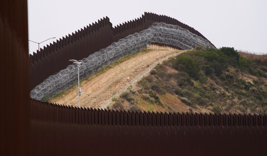 Concertina wire lines the interior of a border wall separating Tijuana, Mexico, from the United States, June 4, 2025, in San Diego. (AP Photo/Gregory Bull, File)