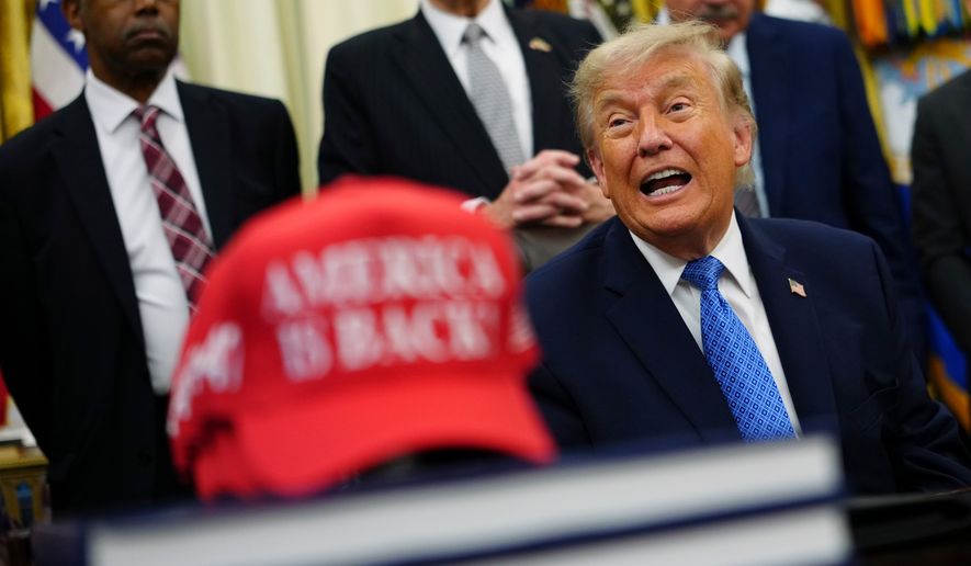 President Donald Trump speaks alongside a red cap stating "America Is Back!" in the Oval Office of the White House, Friday, June 26, 2026, in Washington. (AP Photo/Julia Demaree Nikhinson)