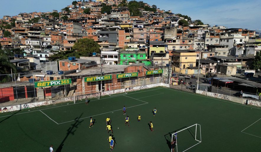 Betting company advertisements adorn a soccer field during a training program in the Complexo do Alemao favela, in Rio de Janeiro, Brazil, July 1, 2023. (AP Photo/Bruna Prado, File)