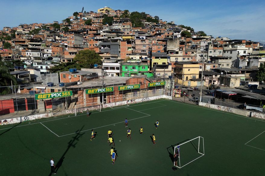 Betting company advertisements adorn a soccer field during a training program in the Complexo do Alemao favela, in Rio de Janeiro, Brazil, July 1, 2023. (AP Photo/Bruna Prado, File)