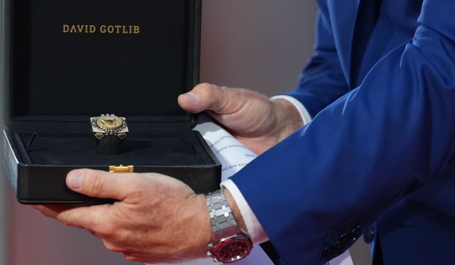 U.S. Ambassador to Belgium Bill White presents a ring designed for U.S. President Donald Trump and crafted by Antwerp diamond designer David Gotlib, during the America 250 event in Brussels, Sunday, June 28, 2026. (AP Photo/Virginia Mayo)