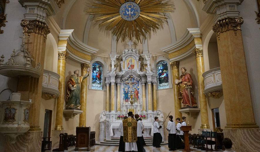 The Rev. John Ubel, pastor of the Church of Saint Agnes, processes into the sanctuary with altar servers at the start of one of the Catholic parish’s Latin Masses in St. Paul, Minn., Sunday, June 28, 2026. (AP Photo/Giovanna Dell’Orto)