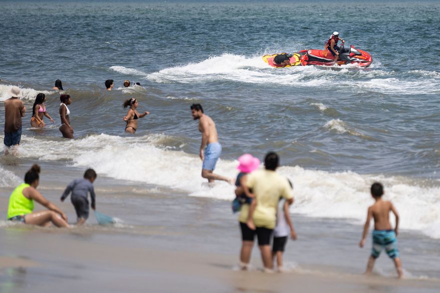 FILE - Lifeguards ride a jet ski during a shark patrol run at Jones Beach State Park, Thursday, July 6, 2023, in Wantagh, N.Y. (AP Photo/John Minchillo,File)