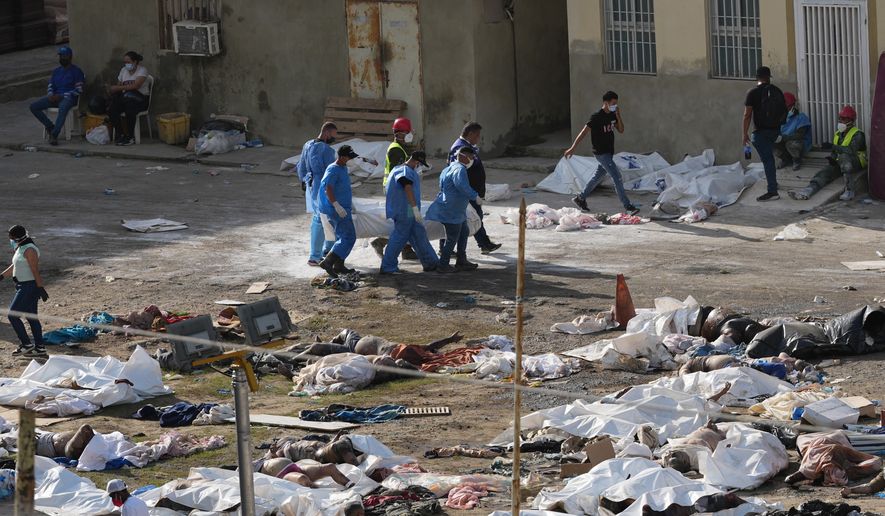 EDS NOTE: GRAPHIC CONTENT - Emergency workers gather the bodies of earthquake victims in the parking lot of a hospital three days after twin earthquakes struck, in La Guaira, Venezuela, Saturday, June 27, 2026. (AP Photo/Matias Delacroix)