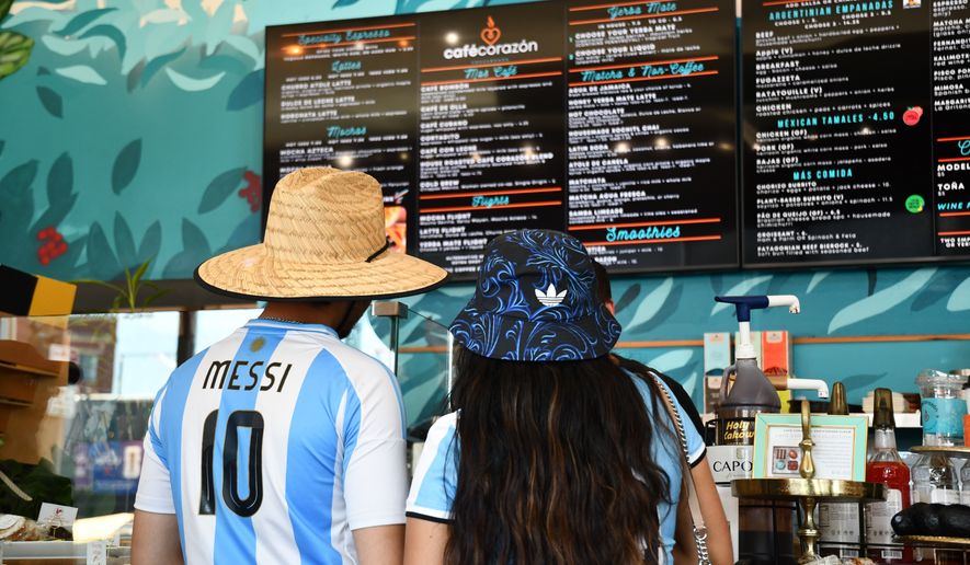 FILE - Fans wearing Argentina national team jerseys look at a menu of drinks at Cafe Corazon, Monday, June 15, 2026, in Kansas City, Mo. (AP Photo/Kristin M. Hall, File)