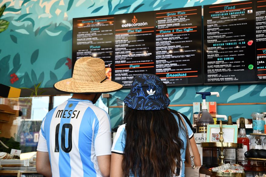 FILE - Fans wearing Argentina national team jerseys look at a menu of drinks at Cafe Corazon, Monday, June 15, 2026, in Kansas City, Mo. (AP Photo/Kristin M. Hall, File)