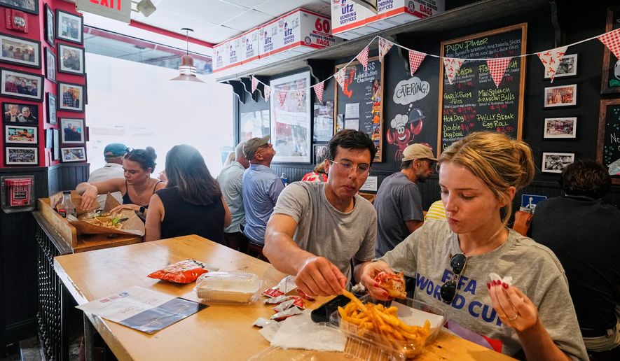 People wearing World Cup shirts taste sandwiches at Pauli's sandwich shop in the North End of Boston, Wednesday, June 24, 2026. (AP Photo/Martin Meissner)