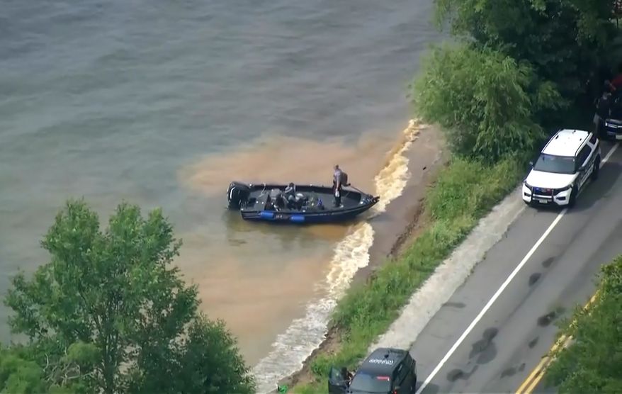 This image made from video provided by WISN-TV shows law enforcement use search boats in Geneva Lake, Wis., after receiving calls of an overturned boat on Friday, July 3, 2026. (WISN-TV via AP)
