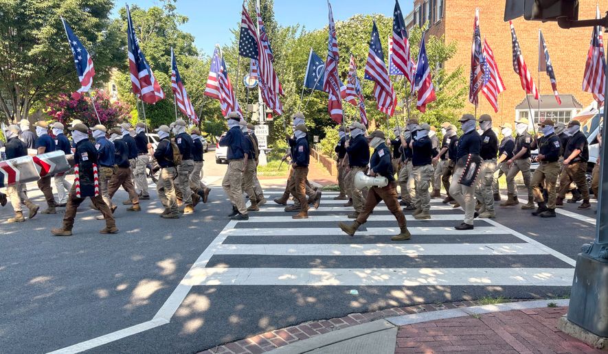 In this image provided by Mark Sherman, members of the group Patriot Front wear masks as they march through Washington before Independence Day events honoring the nation's 250th anniversary, Saturday, July 4, 2026. (Mark Sherman via AP)