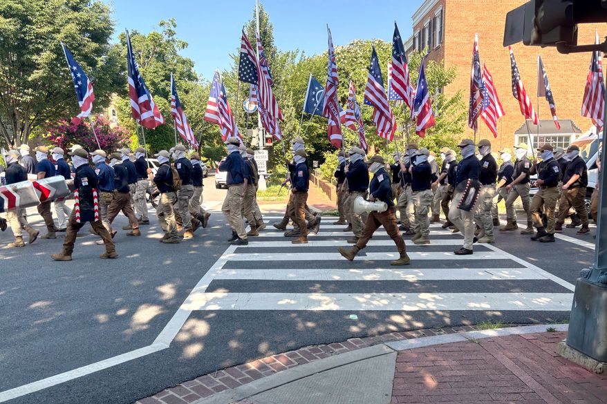 In this image provided by Mark Sherman, members of the group Patriot Front wear masks as they march through Washington before Independence Day events honoring the nation's 250th anniversary, Saturday, July 4, 2026. (Mark Sherman via AP)