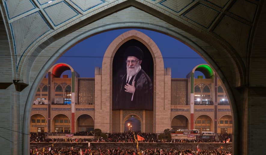 Mourners gather beneath a portrait of the late Iranian Supreme Leader Ayatollah Ali Khamenei during the funeral ceremonies for Khamenei and members of his family at the Imam Khomeini Mosalla Grand Mosque in Tehran, Iran, Saturday, July 4, 2026. (AP Photo/Altaf Qadri)