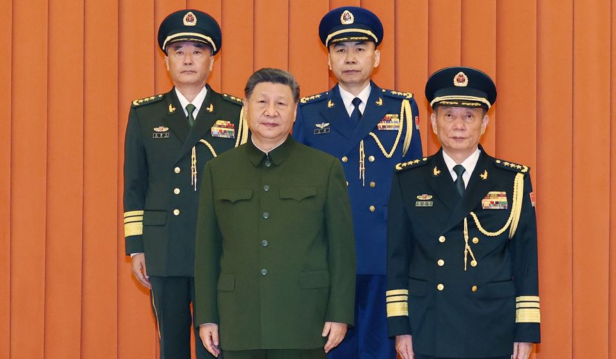 In this photo released by Xinhua News Agency, Chinese President Xi Jinping, bottom left, who is also Chairman of the Central Military Commission (CMC) poses for photos with newly promoted generals Wang Shuguang, top left and Wang Gang, top right while Zhang Shengmin, Vice Chairman of the CMC stands at the right in Beijing, on Friday, July 3, 2026. (Li Gang/Xinhua via AP)
