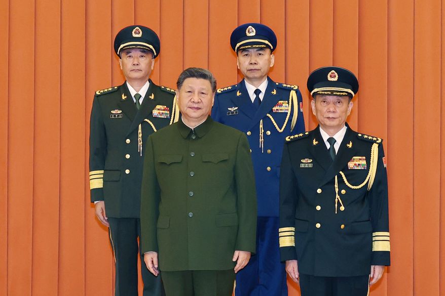 In this photo released by Xinhua News Agency, Chinese President Xi Jinping, bottom left, who is also Chairman of the Central Military Commission (CMC) poses for photos with newly promoted generals Wang Shuguang, top left and Wang Gang, top right while Zhang Shengmin, Vice Chairman of the CMC stands at the right in Beijing, on Friday, July 3, 2026. (Li Gang/Xinhua via AP)