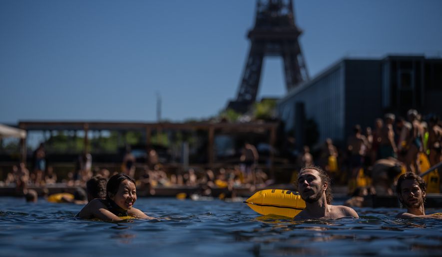 People swim in the Seine River, Saturday, July 4, 2026 in Paris. (AP Photo/Aurelien Morissard)