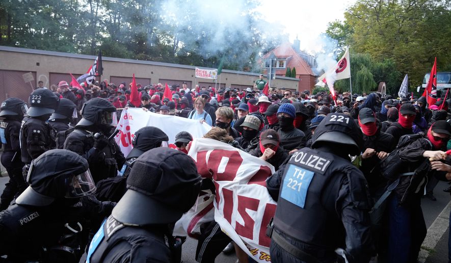 Protesters scuffle with police officers before a party convention of Alternative for Germany, or AfD in Erfurt, Germany, Saturday, July 4, 2026. (AP Photo/Ebrahim Noroozi)