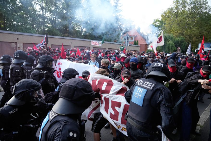 Protesters scuffle with police officers before a party convention of Alternative for Germany, or AfD in Erfurt, Germany, Saturday, July 4, 2026. (AP Photo/Ebrahim Noroozi)