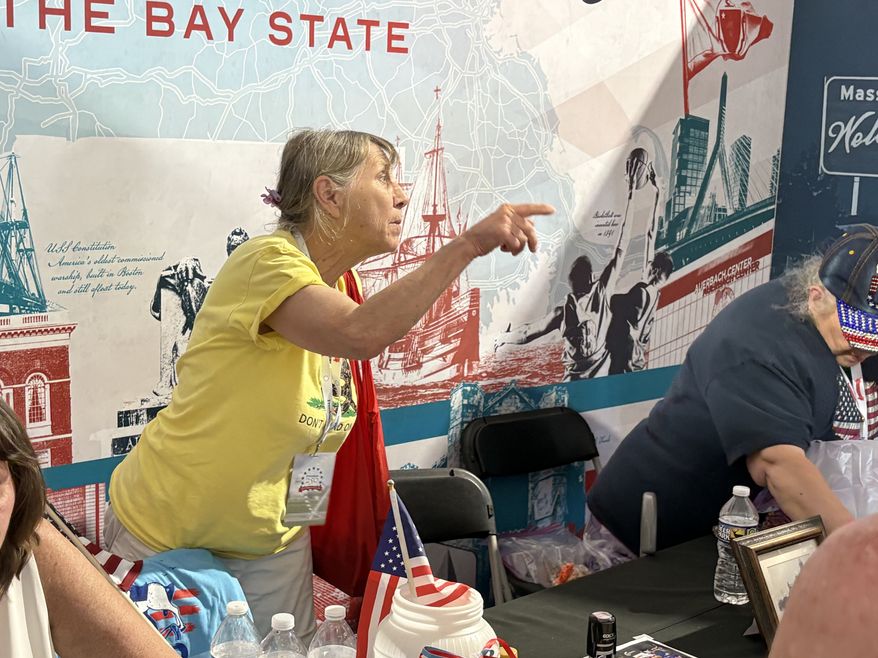 Donna Festinger speaks with a guest while running the Massachusetts exhibit at the Great American State Fair in the District. She said she will be at the event until it closes down on July 10. (Matt Delaney/The Washington Times)