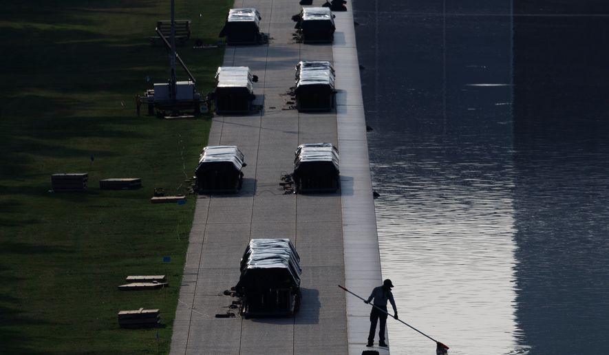 A worker clears debris from the Lincoln Memorial Reflecting Pool, Wednesday, July 1, 2026, in Washington. (AP Photo/Tom Brenner)