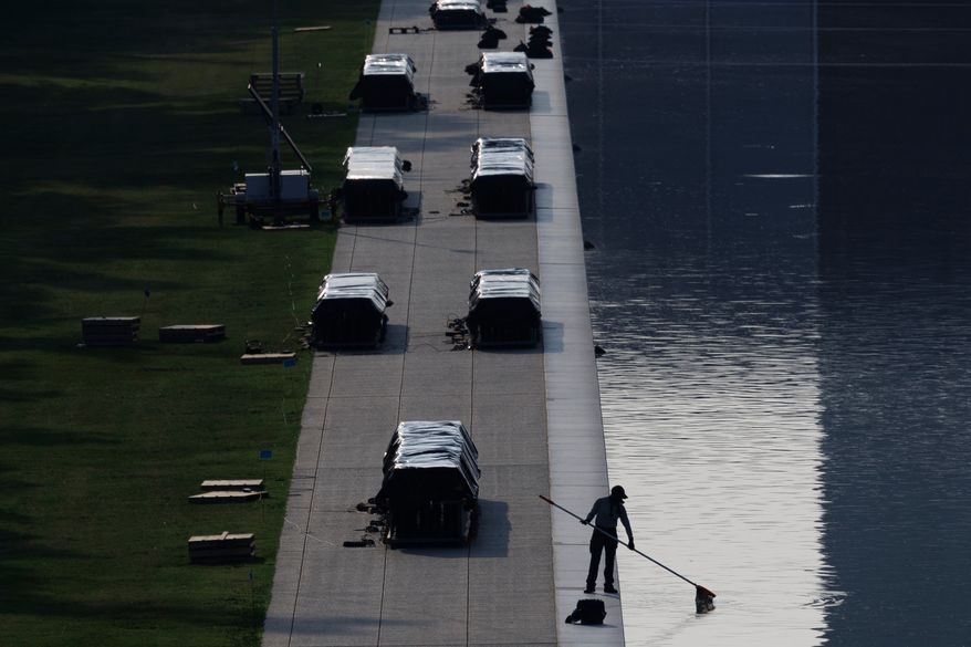 A worker clears debris from the Lincoln Memorial Reflecting Pool, Wednesday, July 1, 2026, in Washington. (AP Photo/Tom Brenner)