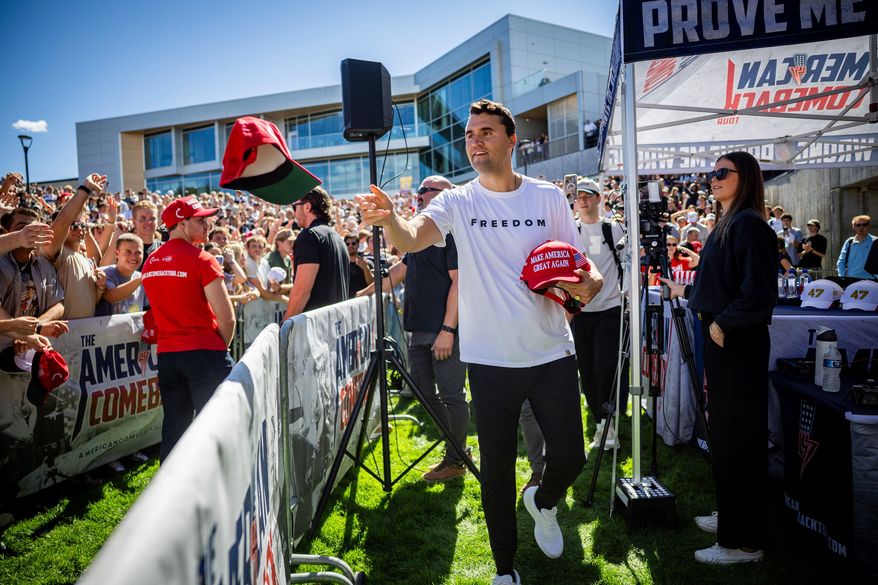 Charlie Kirk hands out hats before speaking at Utah Valley University in Orem, Utah, Sept. 10, 2025. (Tess Crowley/The Deseret News via AP, File)