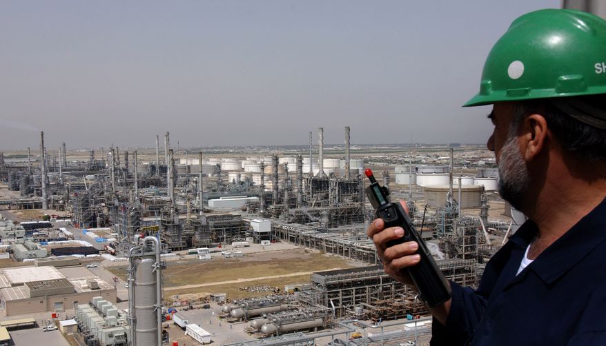 FILE - A Kuwaiti oil worker talks on his radio at Mina Abdulah Oil Refinery, 50 Km South of Kuwait City in this file photo taken April 2005. (AP Photo/Gustavo Ferrari, File)