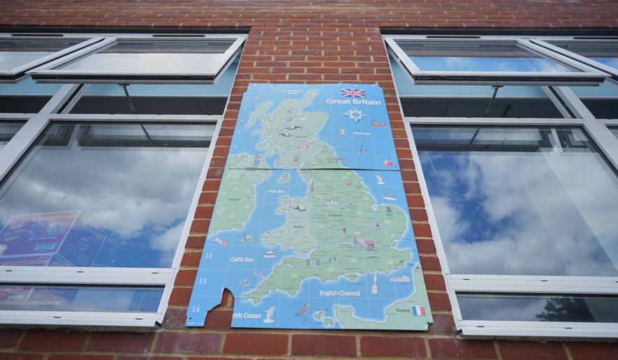 A map of Great Britain on the all next to open classroom window at Beaconsfield Primary School in London, Wednesday, July 1, 2026. (AP Photo/Alastair Grant)
