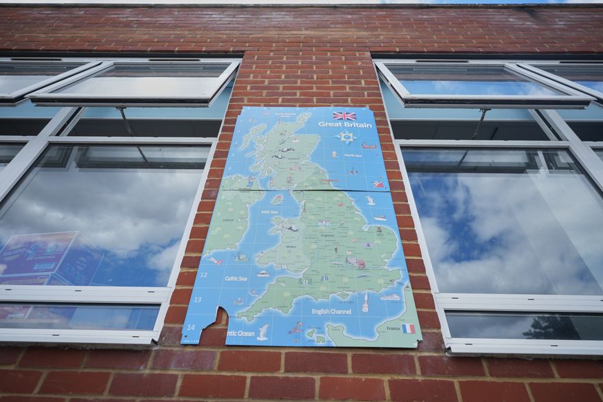 A map of Great Britain on the all next to open classroom window at Beaconsfield Primary School in London, Wednesday, July 1, 2026. (AP Photo/Alastair Grant)