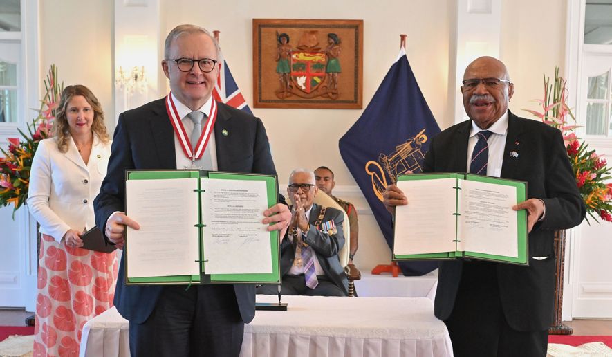 Australia's Prime Minister Anthony Albanese, left, and Fiji's Prime Minister Sitiveni Rabuka display a new bilateral defense alliance they have just signed at State House in Suva, Fiji, Monday, July 6, 2026. (Mick Tsikas/AAP Image via AP)