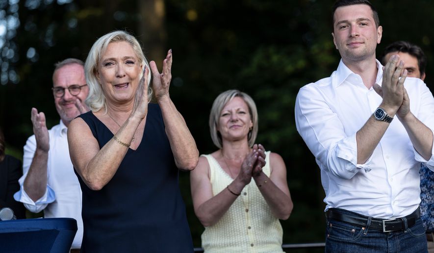 Far-right party National Rally president Jordan Bardella and far-right leader Marine Le Pen applaud during a rally in Lievin, northern France, Saturday, July 4, 2026. (AP Photo/Jean-Francois Badias)