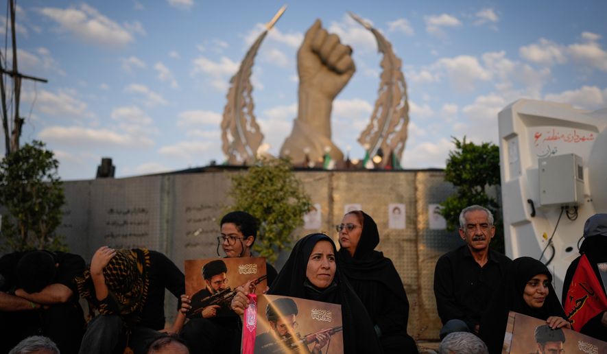 Mourners hold portraits of Iran's new Supreme Leader Mojtaba Khamenei while gathered in Islamic Revolution Square for the funeral procession of the slain Iranian Supreme Leader Ayatollah Ali Khamenei in Tehran, Iran, Monday, July 6, 2026. (AP Photo/Altaf Qadri)