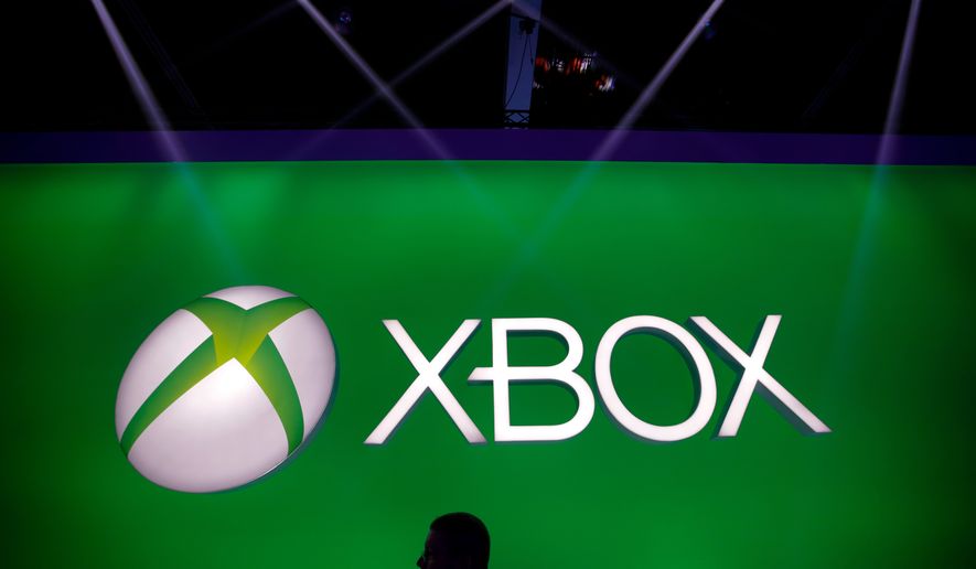 FILE - A man walks past the Xbox logo at the Microsoft booth during the E3 game show in Los Angeles, Tuesday, June 11, 2013. (AP Photo/Jae C. Hong, File)