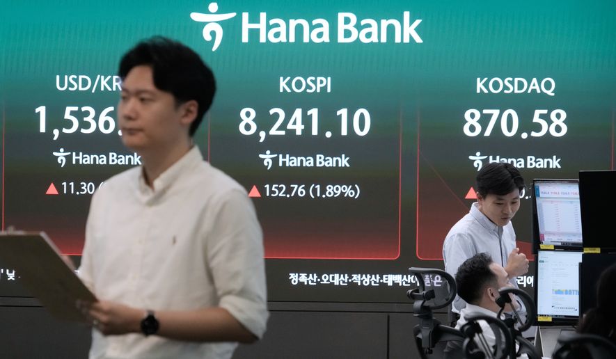 Currency traders work near a screen showing the Korea Composite Stock Price Index (KOSPI) and the foreign exchange rate between U.S. dollar and South Korean won at the foreign exchange dealing room of the Hana Bank headquarters in Seoul, South Korea, Monday, July 6, 2026. (AP Photo/Ahn Young-joon)