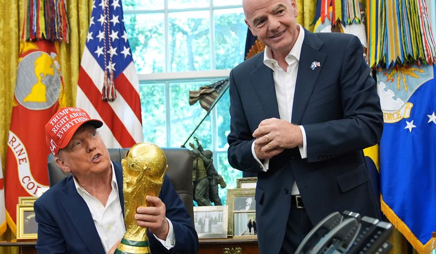 President Donald Trump holds the FIFA World Cup Winners Trophy as FIFA President Gianni Infantino looks on during an announcement in the Oval Office of the White House in in Washington on Aug. 22, 2025. (AP Photo/Jacquelyn Martin) **FILE**