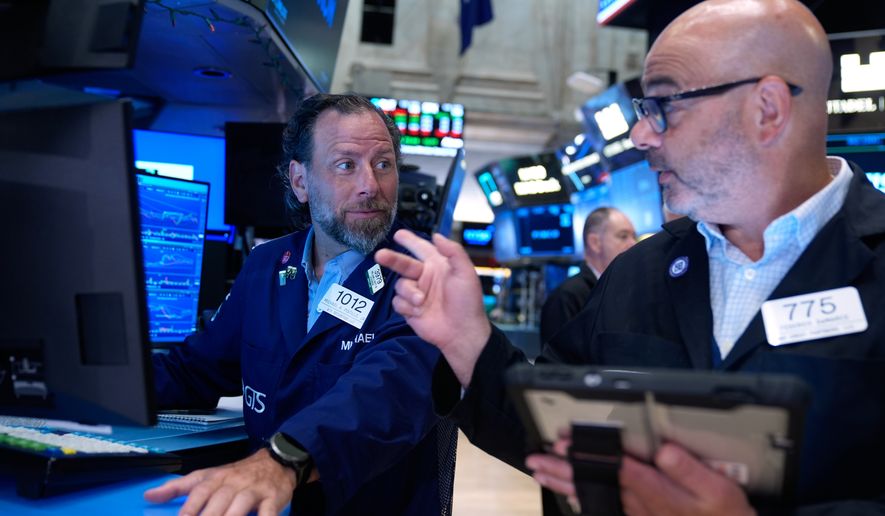 Michael Pistillo, left, and Federico DeMarco work on the floor at the New York Stock Exchange in New York, Monday, July 6, 2026. (AP Photo/Seth Wenig)