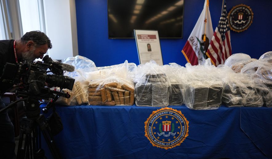 A cameraman records seized evidence at a news conference at the Federal Building in Los Angeles, Tuesday, July 7, 2026. (AP Photo/Jae C. Hong)