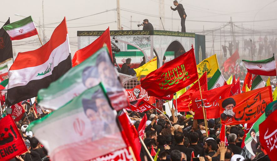 A truck carrying the coffins of the late Iranian Supreme Leader Ayatollah Ali Khamenei and members of his family makes its way through mourners during the funeral procession in Qom, the heart of religious studies in Iran, Tuesday July 7, 2026. (Mohammad Asadi/ISNA via AP)