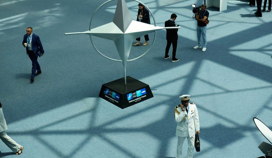 Participants walk near displays during the NATO Defense Industry Forum at the NATO summit in Ankara, Turkey, Tuesday, July 7, 2026. (AP Photo/Hussein Malla)