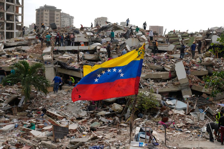 Residents and rescue workers on Thursday, July 2, 2026, search through the rubble of buildings damaged in the earthquakes that struck La Guaira, Venezuela, days earlier. (AP Photo/Ariana Cubillos) **FILE**