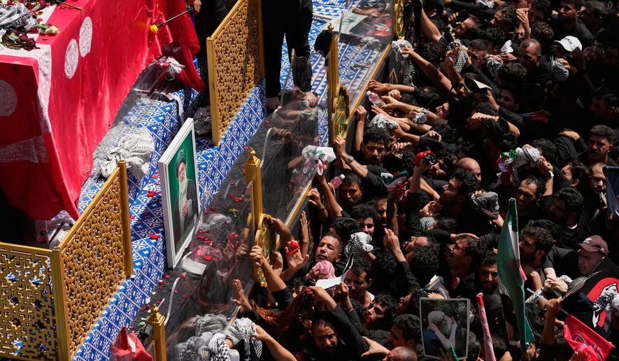Mourners reach toward a truck carrying the coffin of Iranian Supreme Leader Ayatollah Ali Khamenei during a funeral procession in Najaf, Iraq, Wednesday, July 8, 2026. (AP Photo/Hadi Mizban)