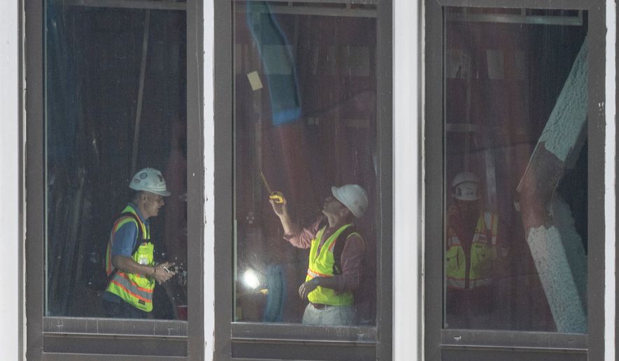 People inspect a buckled support beam inside 235 East 42nd Street, Wednesday, July 8, 2026, in New York. (AP Photo/Yuki Iwamura)
