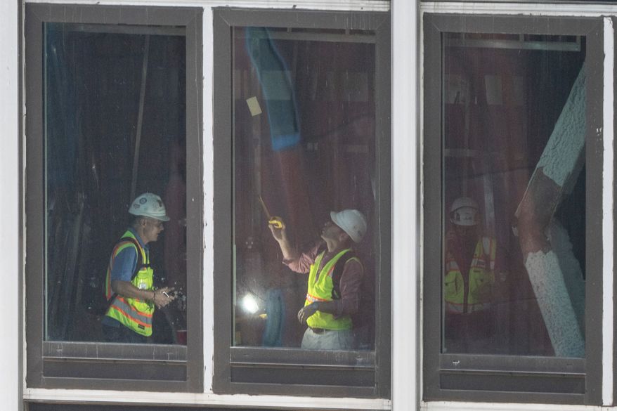 People inspect a buckled support beam inside 235 East 42nd Street, Wednesday, July 8, 2026, in New York. (AP Photo/Yuki Iwamura)