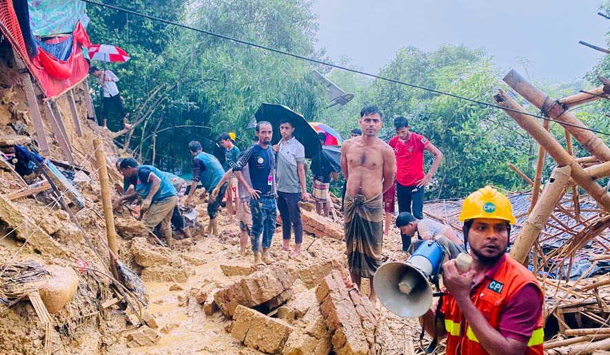 Rescuers work at the site of a landslide at a Rohingya refugee camp in Cox's Bazar, Bangladesh, Wednesday, July 8, 2026. (AP Photo/Shamimul Islam Faisal)