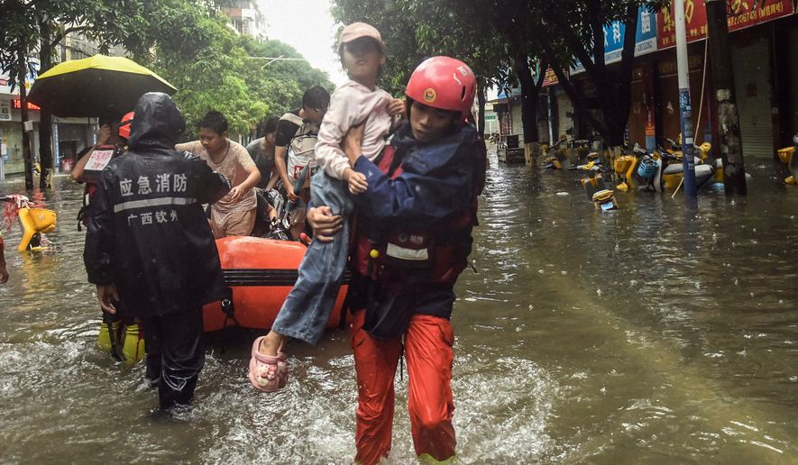 In this photo released by Xinhua News Agency, rescuers evacuate stranded residents in the aftermath of tropical storm Maysak in Qinzhou City, south China's Guangxi Zhuang Autonomous Region Tuesday, July 7, 2026. (Zhang Ailin/Xinhua via AP)