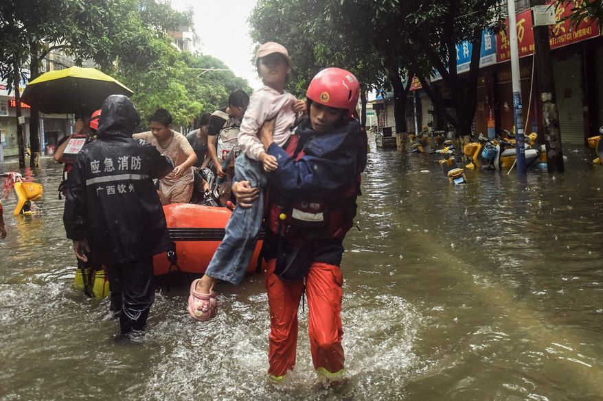In this photo released by Xinhua News Agency, rescuers evacuate stranded residents in the aftermath of tropical storm Maysak in Qinzhou City, south China's Guangxi Zhuang Autonomous Region Tuesday, July 7, 2026. (Zhang Ailin/Xinhua via AP)