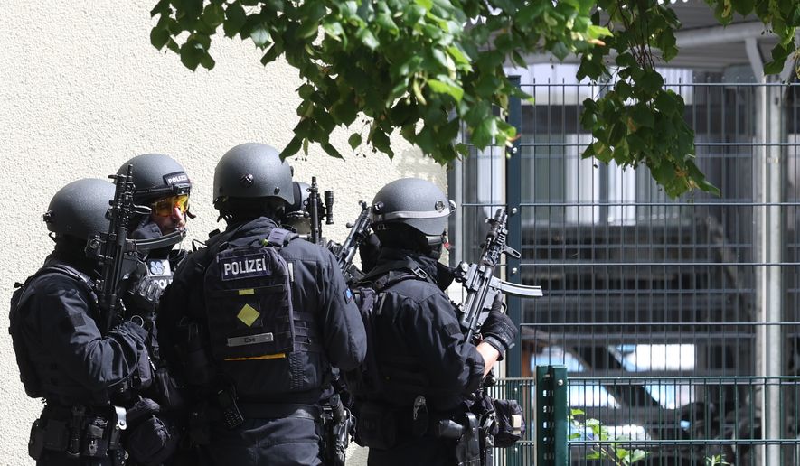 Heavily armed police officers guard at the Welfen High School, Schongau, Germany, Wednesday, July 8, 2026. (Karl-Josef Hildenbrand/dpa via AP)