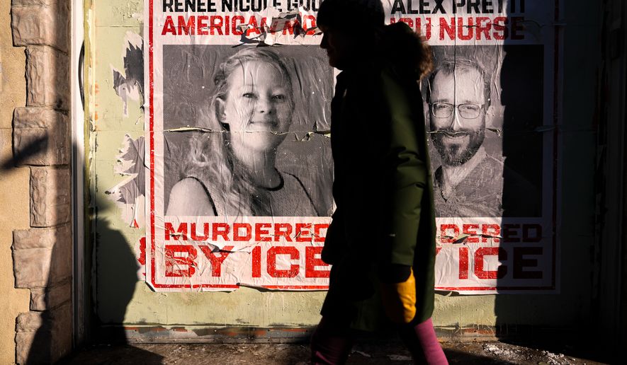 FILE - A woman walks by posters of Renee Good and Alex Pretti during a solidarity bike ride for Pretti, Jan. 31, 2026, in Minneapolis. (AP Photo/Julia Demaree Nikhinson, File)