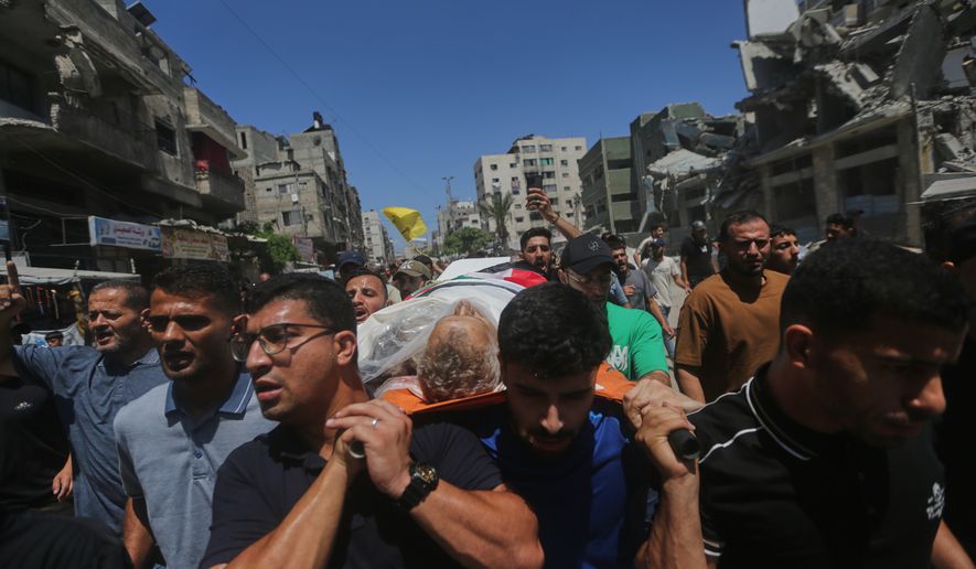 Palestinians carry the body of Mohamed al-Wahidi, director of public relations for the Egyptian Committee in Gaza, who was killed in an Israeli military strike, during his funeral in Gaza City, Wednesday, July 8, 2026. (AP Photo/Yousef Al Zanoun)